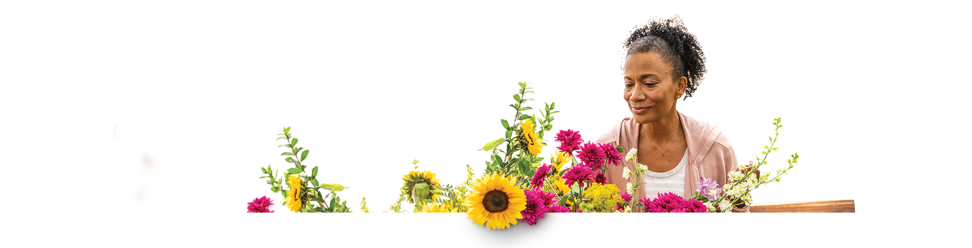 Woman in greenhouse admiring flowers